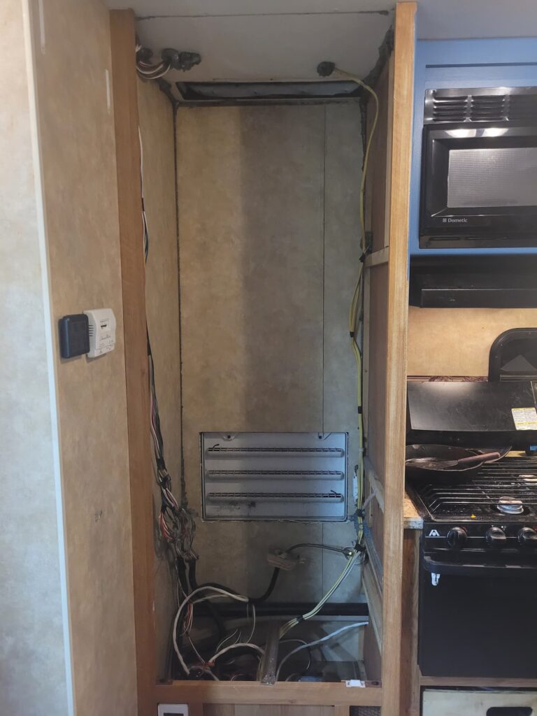 Photo of cavity in RV kitchen where fridge used to be