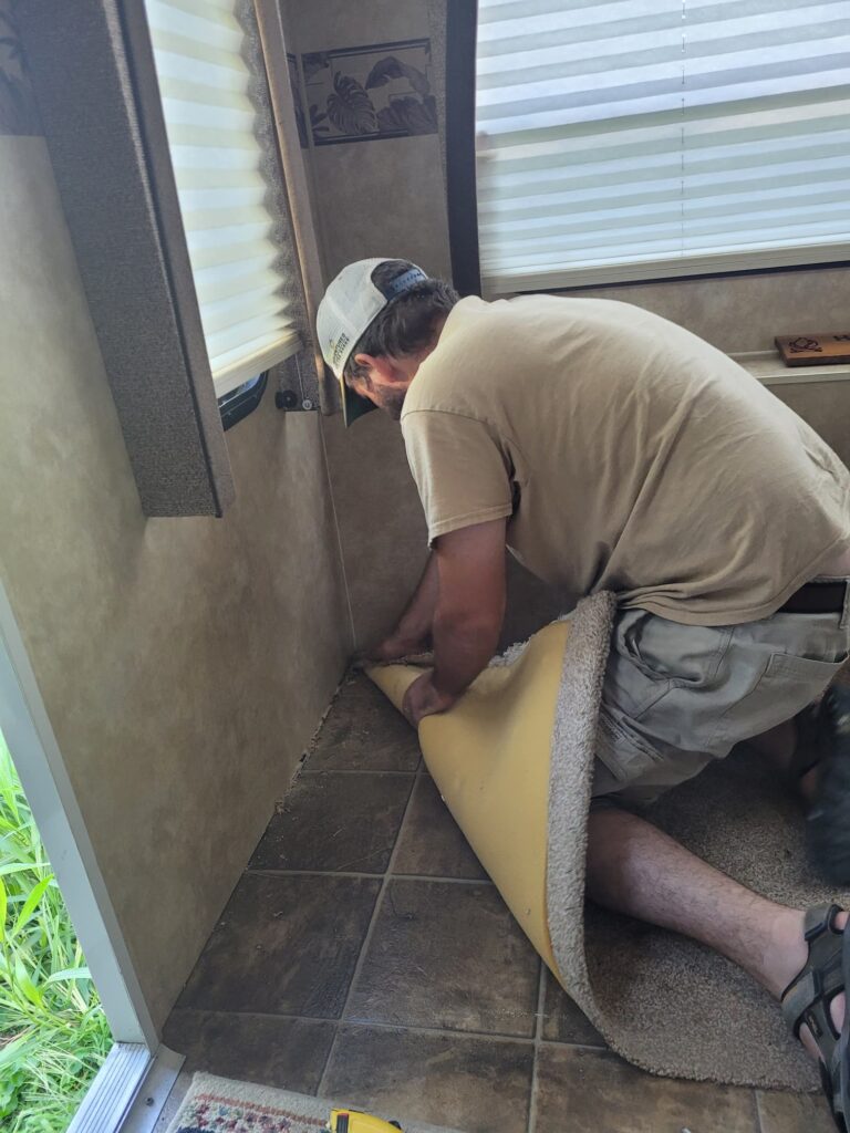 Photo of Josh removing carpet from RV