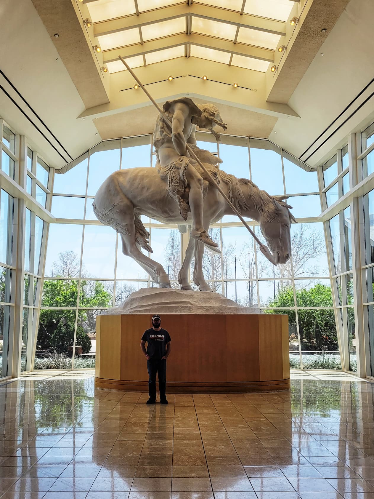 photo of josh in front of statue at national cowboy museum