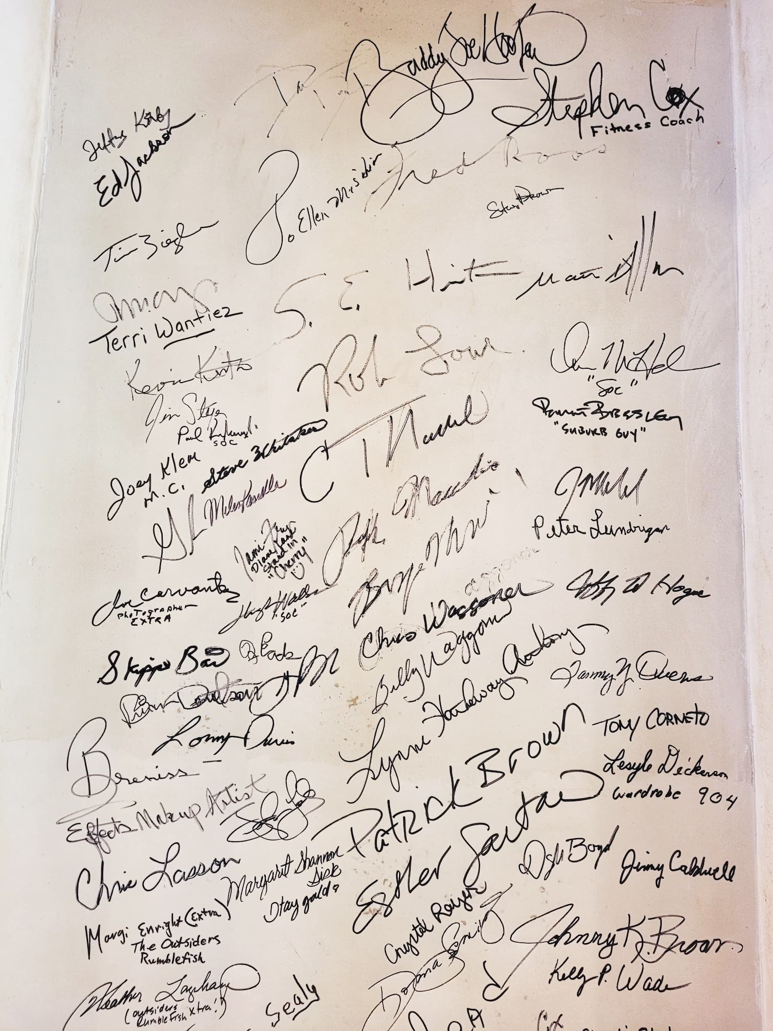 photo of autographs on wall of outsiders house